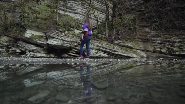 Отражение в воде девушки, идущей по каменной скале . — стоковое видео