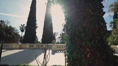 Sevimli kız güneşli bir günde güzel bir bahçede antika bir terasta yürüyor