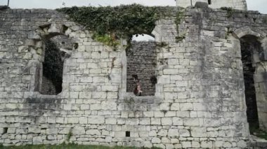 Güzel kız eski bir kalenin penceresinde duruyor ve bir prenses gibi pencereden dışarı bakar, genel plan