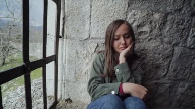 Kız bir taş kalenin parmaklıklar arkasında çok üzgün