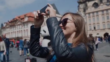 Güneş gözlüğü güzel kız kalabalık bir meydanın merkezinde turistik fotoğraflar