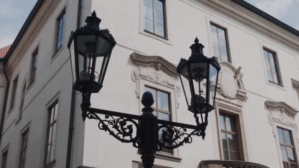 Dubbel Street Black metal lampa nära historiska vita byggnaden i centrum av staden — Stockvideo
