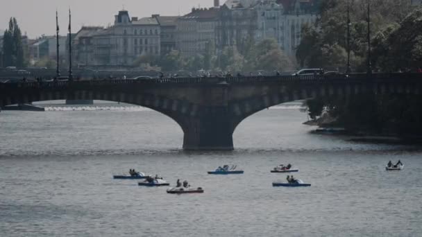 Schilderachtig uitzicht op catamarans op de rivier de Vltava, de oude brug en de historische gebouwen van Praag, Praag, Tsjechië — Stockvideo