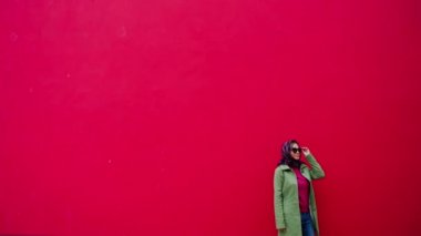 Kırmızı moda arka plan üzerinde eşarp ve güneş gözlüğü ile Glamor güzel kadın