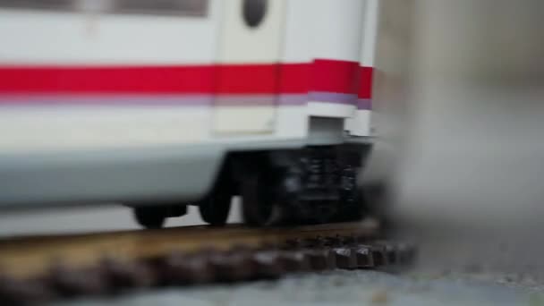 Modell von Hochgeschwindigkeits-Elektro-Expresszugfahrten auf dem Modell der Eisenbahn auf einer Stadtstraße. Nahaufnahme von Rädern — Stockvideo