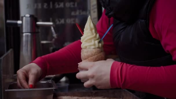 Elárusítónő díszíti trdelnik friss eper, és adja meg a turista. Sütés trdelnik van közelről, női kezek — Stock videók