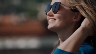 güneş gözlüğü gülümseyen kız rüzgardan sallayarak saçlarını ayarlar