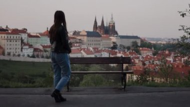 buket ile güzel kız Prag manzaralı yalnız tezgah yaklaşımlar, üzerine oturur ve etrafında ne kadar güzel görünmeye başlar
