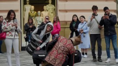 Prag, 16 Mayıs 2019: Turistler kamera da fotoğraf çekmek, synthesizer arkasında at kostümü neşeli sokak müzisyeni ilgi ile bakmak, arka görünüm