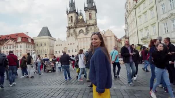 ПРАГА, 16 МАЯ 2019: Девушка в желтой юбке прогуливается по Староместской площади в Праге, Чехия — стоковое видео