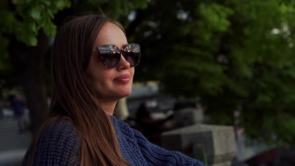 Süßes nachdenkliches Mädchen mit Sonnenbrille im Abendlicht — Stockvideo