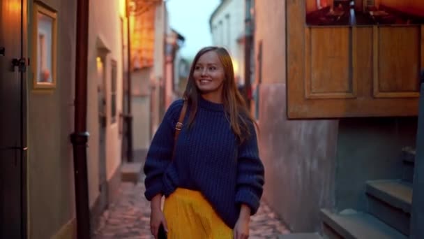 Glückliches Mädchen spaziert durch die enge Abendstraße der Altstadt, Frontansicht, Portrait — Stockvideo