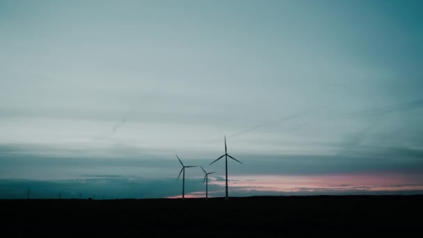 Windparks in der Windenergie-Erzeugung bei buntem Sonnenuntergang. landschaftliche Technologielandschaft. Mechanische Energie wird in elektrische Energie umgewandelt, Generalplan — Stockvideo