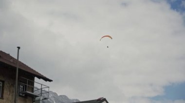Bulutlu gökyüzüne karşı renkli sarı kırmızı paraşüt ile skydiver Figürü