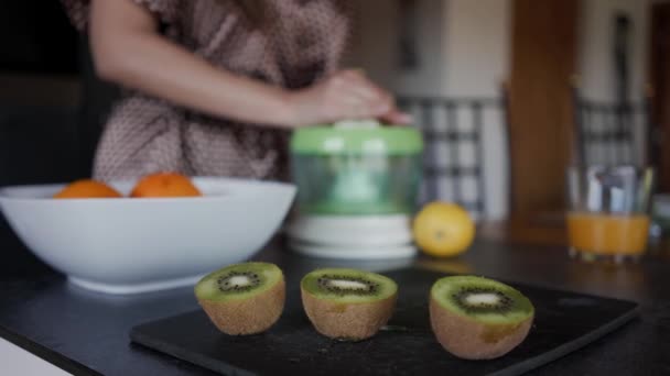 Herstellung von frischem Kiwisaft. Kiwi-Stücke im Vordergrund. Nahaufnahme — Stockvideo