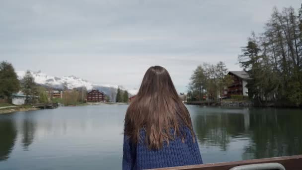 Brunette fille aux cheveux longs assis et regardant un beau paysage de montagne en face d'elle. Vue arrière — Video