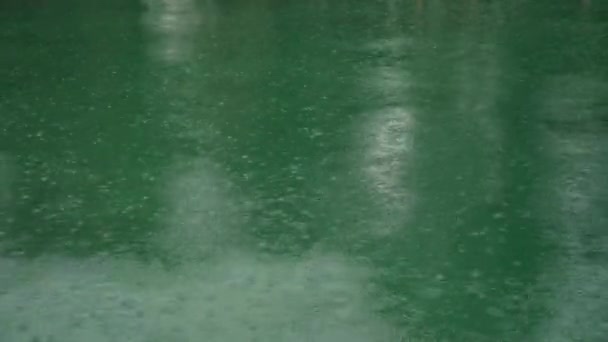 Rain drop falling on blue pond and have ripple shape on surface. Abstract background — Stockvideo