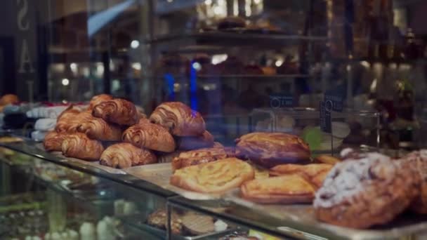 Croissants recién horneados y varios pasteles gourmet a la venta en la panadería parisina. De cerca. Cocina tradicional francesa — Vídeo de stock