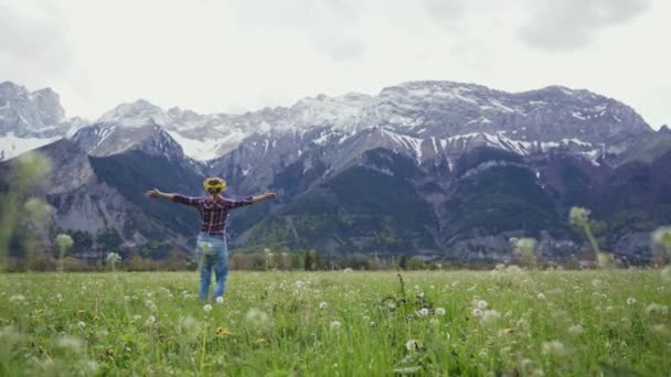 Dolce donna in una corona sta camminando su un prato alpino, felicemente vorticoso con le mani in alto — Video Stock