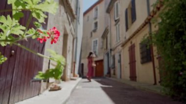 Güzel kız eski şehrin sokaklarında dönüp duruyor. Arka plan bulanık. Uzak plan