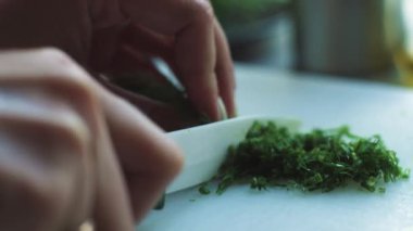 Beyaz bir tahtada maydanoz dilimlemek, kadın elleri yavaş çekimde yakın çekimde alınmış. Avantajlar