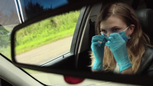 一个女人在车上戴着医疗面罩 Coronavirus 从车镜看Covid — 图库视频影像