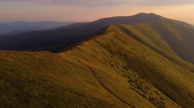 Alp dağlarının hava görüntüsü. Dağlar, tepeler, uçurumlar, kayalar, çıkıntılar, manzara, yeşil çimenler, gökyüzü, bulutlar, doğa, işlenmemiş doğa, drone videosu.