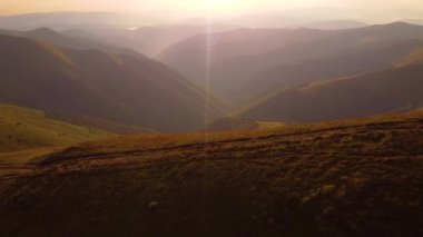 Bulutlu yaz havasında yeşil ladin ormanlarıyla kaplı yüksek dağların havadan görünüşü.