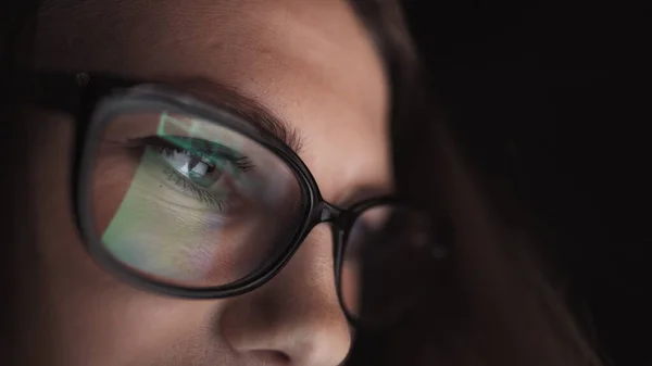 Atractiva joven mujer de negocios que trabaja por la noche a través de la computadora en la oficina con, primer plano de la chica estudiante hipster navegar por Internet, mirando el monitor de la computadora moderna, se centran en las gafas —  Fotos de Stock