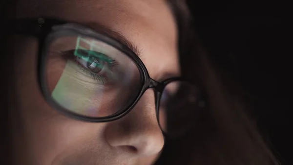 Atractiva joven mujer de negocios que trabaja por la noche a través de la computadora en la oficina con, primer plano de la chica estudiante hipster navegar por Internet, mirando el monitor de la computadora moderna, se centran en las gafas —  Fotos de Stock