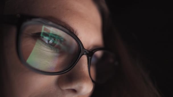 Atraktivní mladá podnikatelka pracující v noci přes počítač v kanceláři s, detailní záběr hipster studentské dívky procházející internet, při pohledu na monitor moderního počítače, zaměření na brýle — Stock video