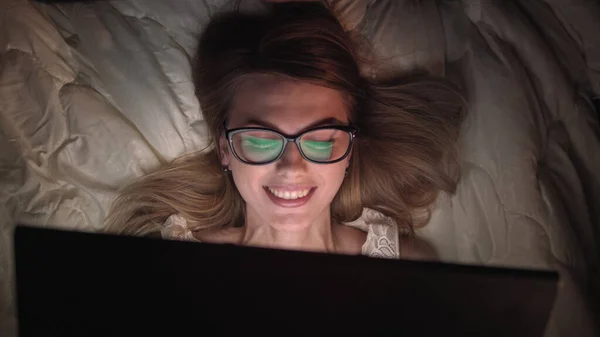 Top View Young Woman i sengen jobber på en laptop-datamaskin om natten. Student som gjør seg klar til eksamen, unntaksvis dedikert prosjektleder som fullfører arbeidet i sengen om natten. – stockfoto