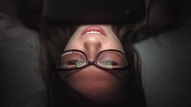 Kadınlar geceleri cep telefonlarına bakar.