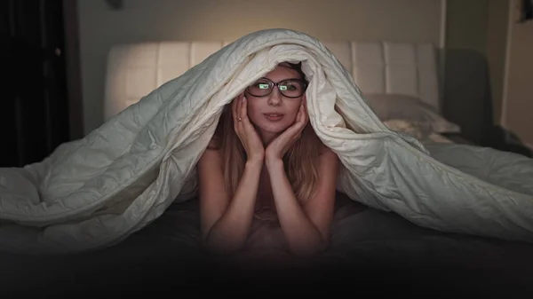 woman watching sadness drama movie from television at home at night. Girl feeling sad and crying after seeing on TV wipe tears away from her eyes.