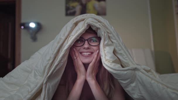 Donna gioisce guardando commedia a casa, ragazza sdraiata sul letto sotto la coperta — Video Stock