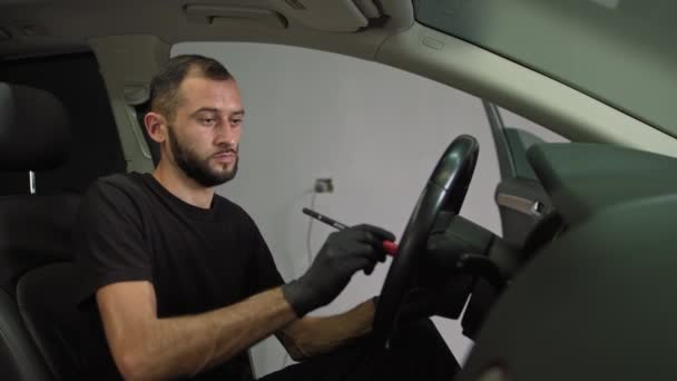 Professzionális autó belső tisztítás.A férfi törli a port az autóban, kefélés a szennyeződéstől — Stock videók
