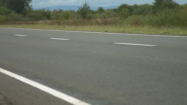 Macchinari da costruzione fa una strada in una piccola città, villaggio. Industrializzazione, sviluppo urbano. Costruzione di una nuova strada. Riparazione della superficie stradale — Foto Stock