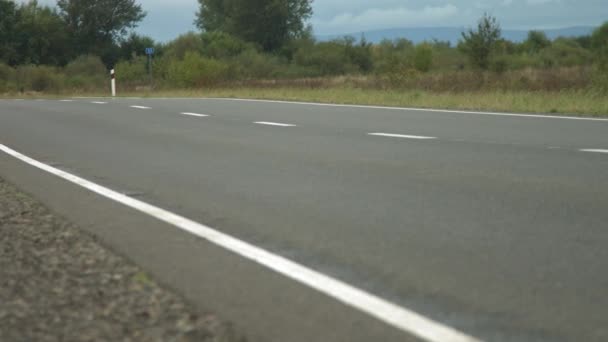 Maquinaria de construcción hace una carretera en una pequeña ciudad, pueblo. Industrialización, desarrollo urbano. Construcción de una nueva carretera. Reparación de carreteras — Vídeos de Stock