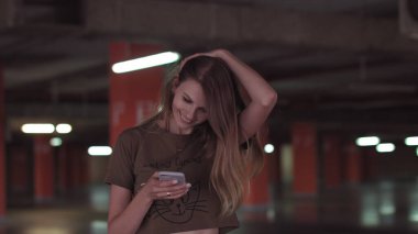 Rahat genç bir kadın akıllı telefon kullanarak sosyal medyada sörf yapıyor, haberleri kontrol ediyor, mobil oyunlar oynuyor ya da süpermarketin otoparkında mesaj yazıyor..