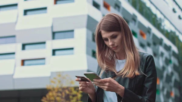 Smilende ung kvinnelig kunde med kredittkort og smarttelefon, på moderne hjemmebakgrunn. Happy Women shopper bruker enkle mobilbetalinger mens du handler på nettet. Elektronisk banktjeneste – stockfoto