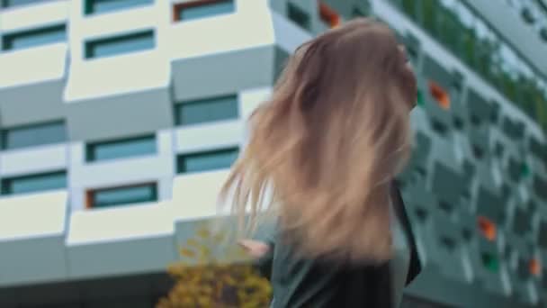 Vellykket ung pige hopper af glæde på baggrund af kontoret – Stock-video