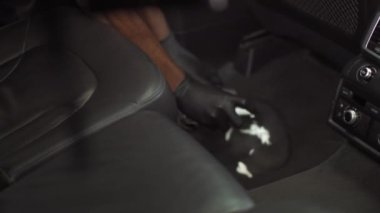 Adam halıyı temizlemek için köpük sürüyor, halı ve arabanın içini dezenfekte ediyor.