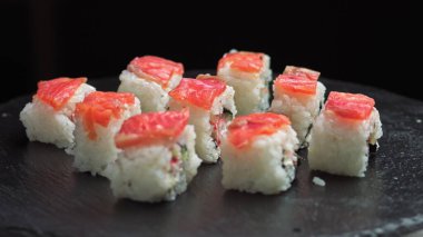 Suşi sırayla. Makro taze Philadelphia suşisi. Balık, somon, pirinç, salatalık. Suşi restoranı, suşi teslimatı. Seçici odak