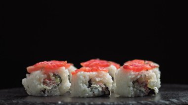 Bir Japon restoranında öğle yemeği. Suşi yiyen adam. Balıktan, somondan, pirinçten, salatalıktan Philadelphia suşisi. Suşi restoranı, suşi teslimatı. Seçici odak