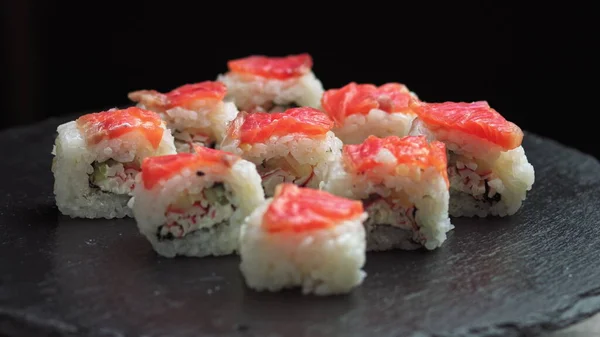 寿司是轮流的。从鱼、鲑鱼、米饭、黄瓜中取出的一套新鲜费城寿司。寿司餐厅寿司送货上门有选择的重点 — 图库照片