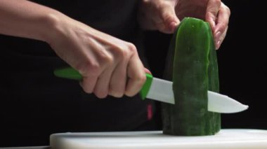 Sebze doğrayan bir kadın. Vejetaryenlik ve diyet konsepti. Salata için taze sulu bir dilim. Tarzlı Taze Salatalık - Suşi Tabağı Dekorasyonu - Yakın çekim, yavaş çekim.