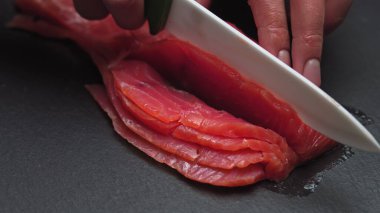 Şef, somon filetosundan kemikleri çıkartıyor. Yavaş çekimde suşi pişirmek için dilimlere ayırıyor.