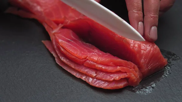 Chef tira ossos do filé de salmão, cortando peixe em fatias para cozinhar sushi em resolução 4k em câmera lenta — Fotografia de Stock