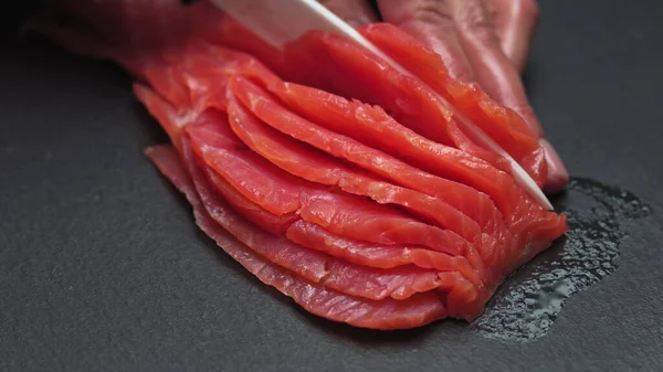 Chef tira ossos do filé de salmão, cortando peixe em fatias para cozinhar sushi em resolução 4k em câmera lenta — Fotografia de Stock