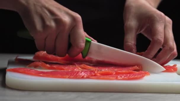 Šéfkuchař krájí filety čerstvého lososa na velké kusy. Vaření ryb v kuchyni. Příprava přísad šéfkuchařem na přípravu pokrmů. Vaření v kuchyni restaurace. Potravinové suroviny pro gurmány — Stock video